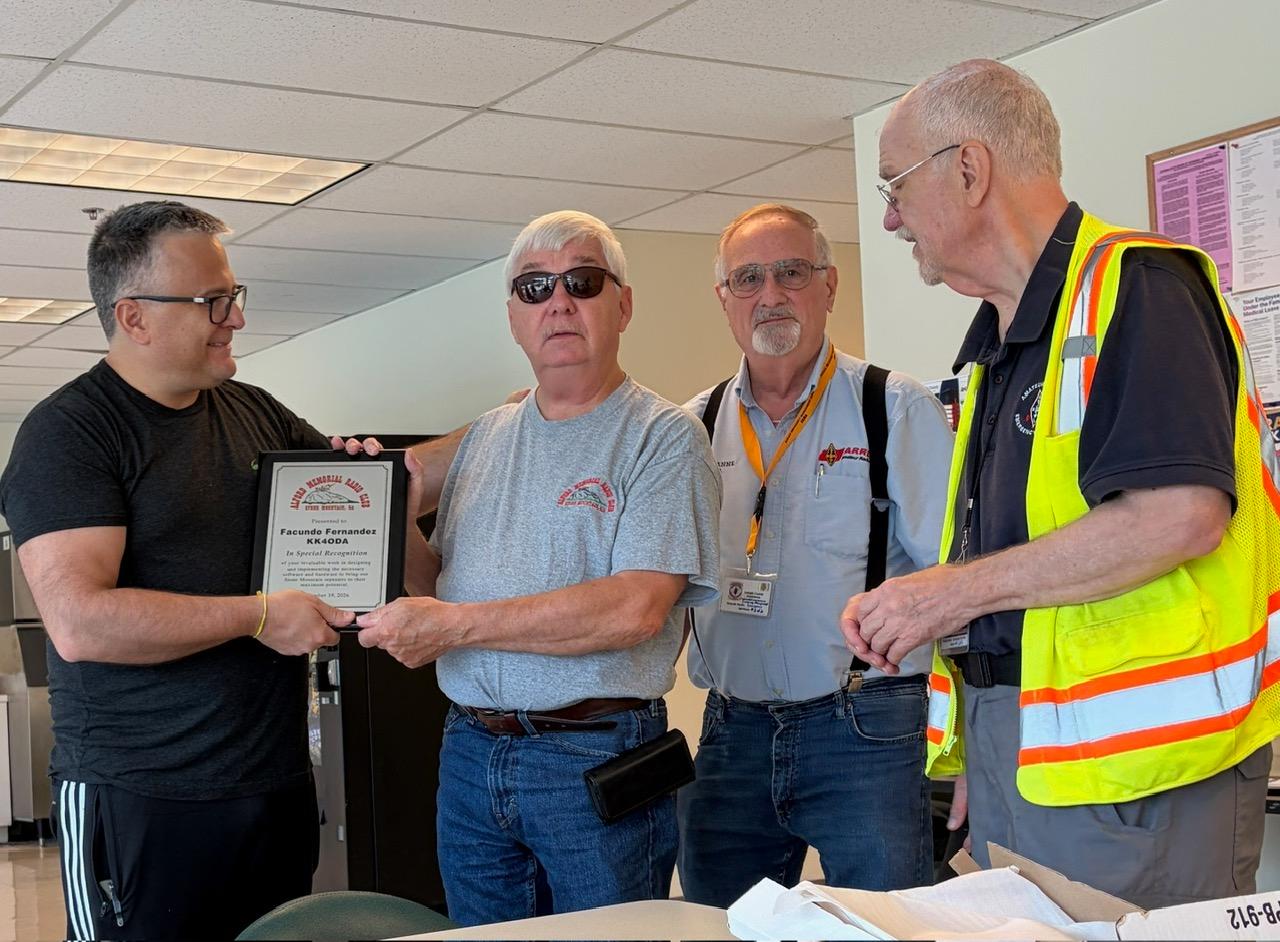 Facundo Fernandez, KK4ODA, receiving his plaque from club officers